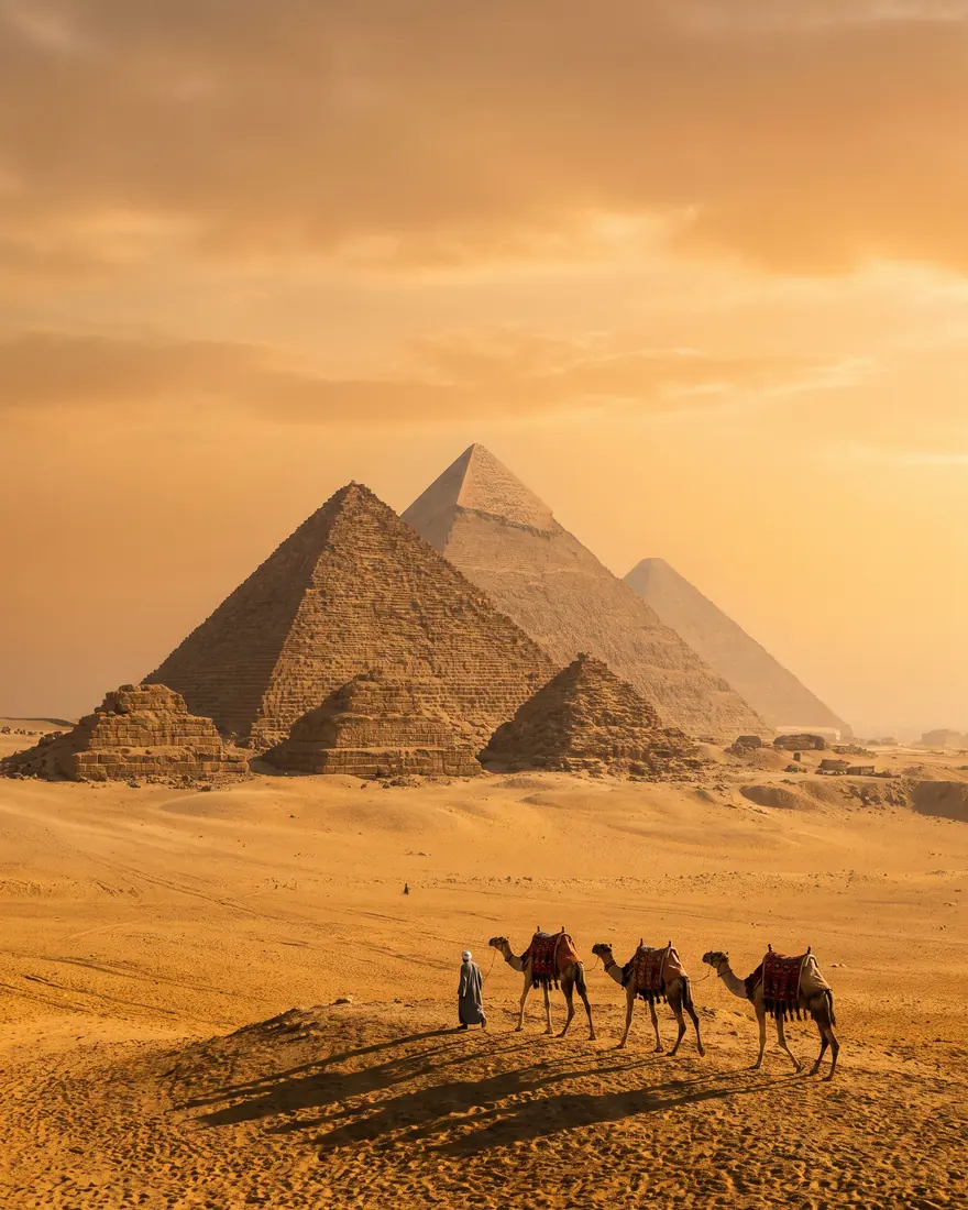 Pirámides de Guiza con camellos al atardecer en Egipto
